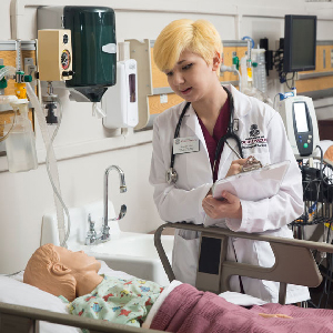 Students work with a mannequin at the nursing simulation lab