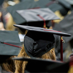 graduate wears cap and gown at a commencement ceremony