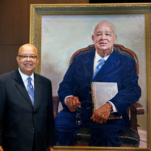 I.S. Leevy Johnson stands next to his portrait. 