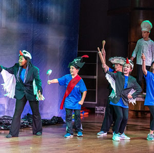 Kids in costumes enjoy creative time on stage for theater camp