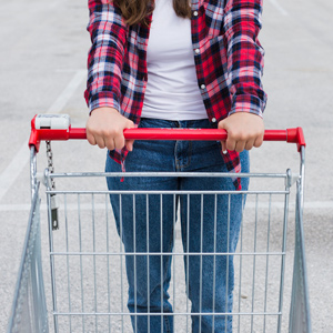 person holds an empty shopping cart with both hands