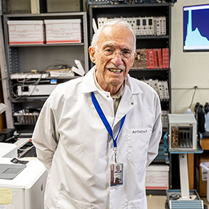 Frank Avignone poses in lab with a white lap coat on. 