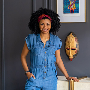 Amber Guyton standing next to a table in front of a wall with decorative wall art.