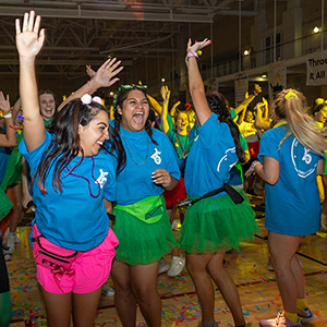 Students with their hands in the air while they dance at USC's Dance Marathon.