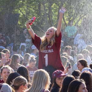 A student celebrates the womens national basketball championship at the Thomas-Cooper reflecting pool.