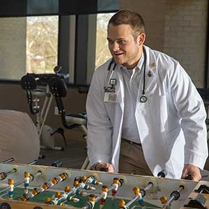 School of Medicine Greenville student plays foosball in student lounge. 
