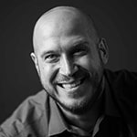 Black and white headshot of Robert LeHeup smiling.