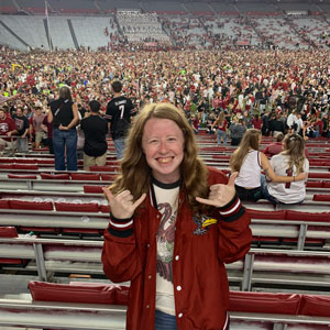 woman standing in a football stadium giving the 