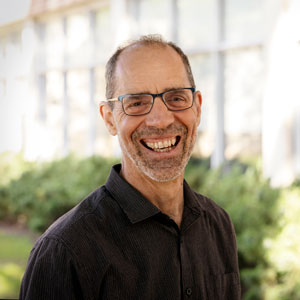 Carbone smiles broadly outside a building on campus.