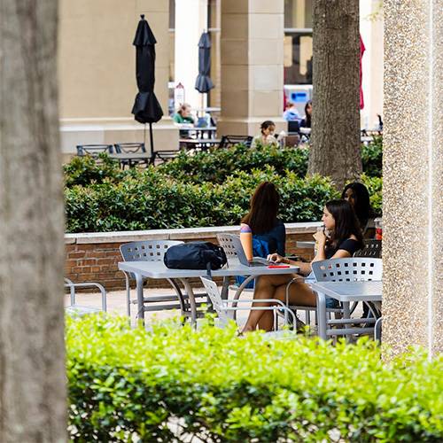 people sit outside the humanities building.