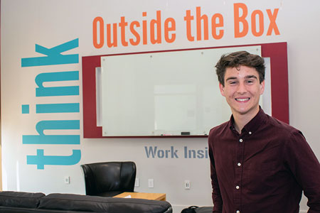 Kevin Gagnon in front of a wall that says "think outside the box"