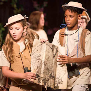 two students in safari costumes with a map