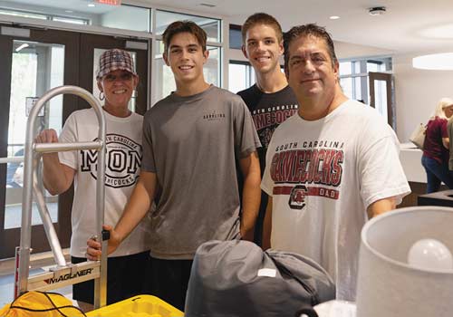 Zach Stauffer with his parents and roommate on move-in day.