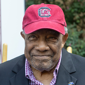 man in garnet USC hat smiles 