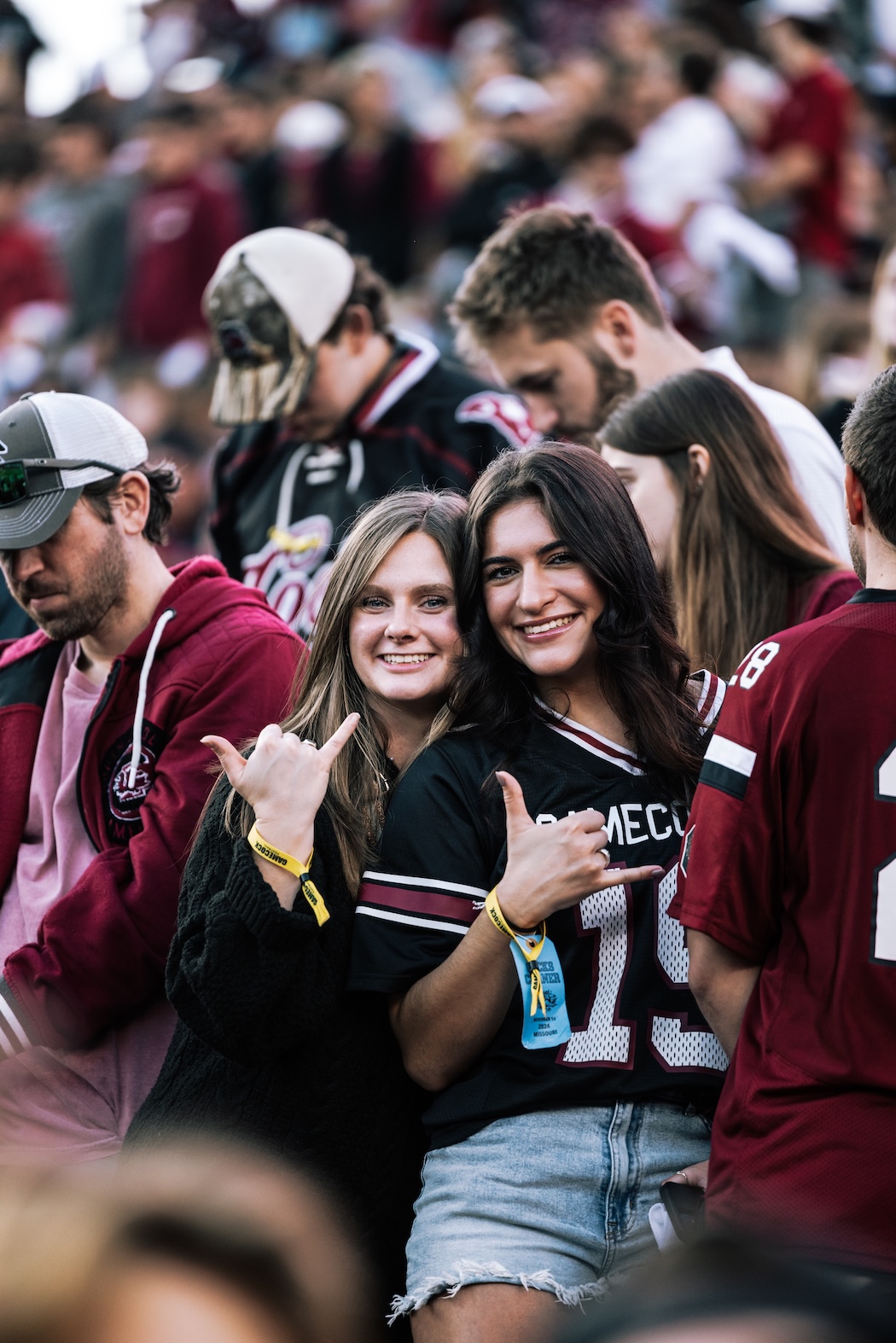 Two girls smiling and holding up spurs with Carolina jerseys