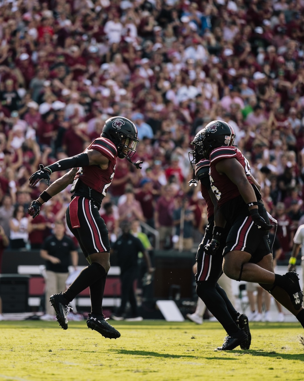 Two football players running towards each other to celebrate.