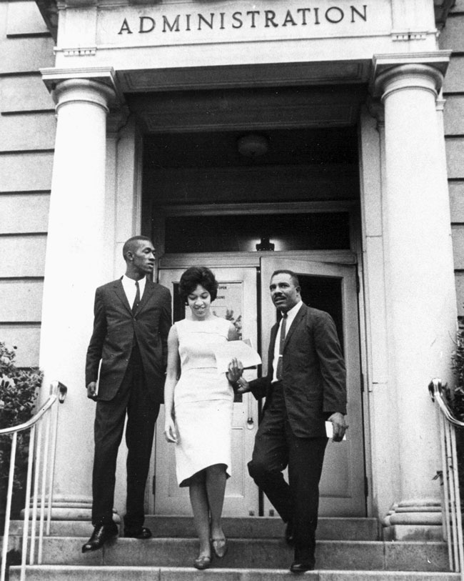 Teenage Henrie Monteith crosses campus flanked by fellow incoming students Robert Anderson (left) and James Solomon Jr. on her way to register for classes, Sept. 11, 1963. Courtesy of University Archives