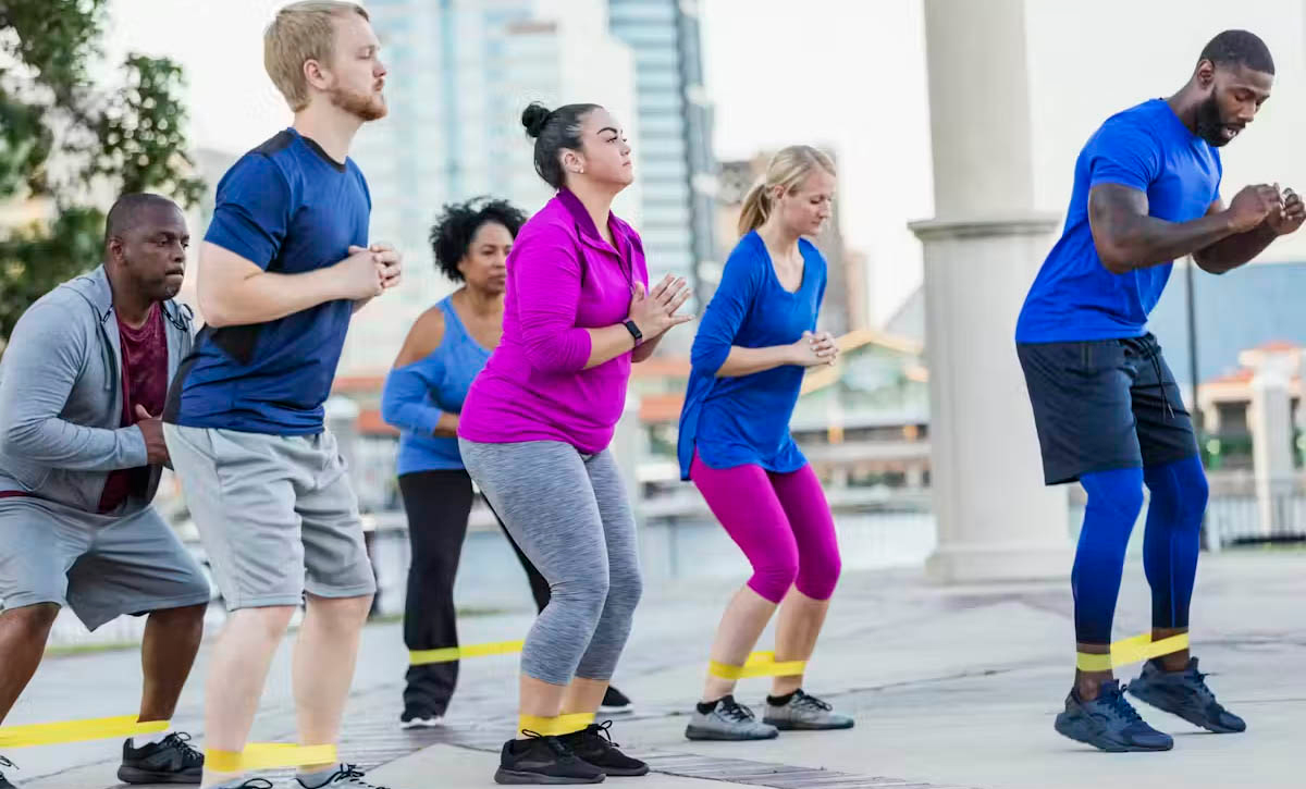 An instructor leads an outdoor exercise class.