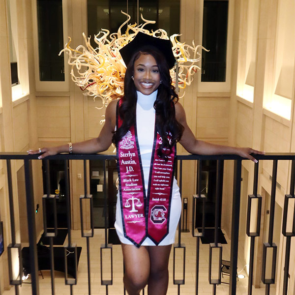 Sterlyn Austin poses in regalia in the law school